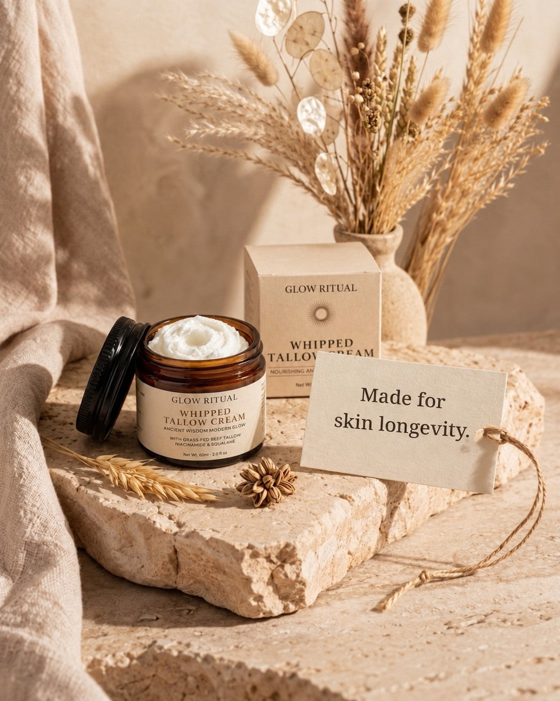 Glow Ritual Whipped Tallow Cream jar and box on stone