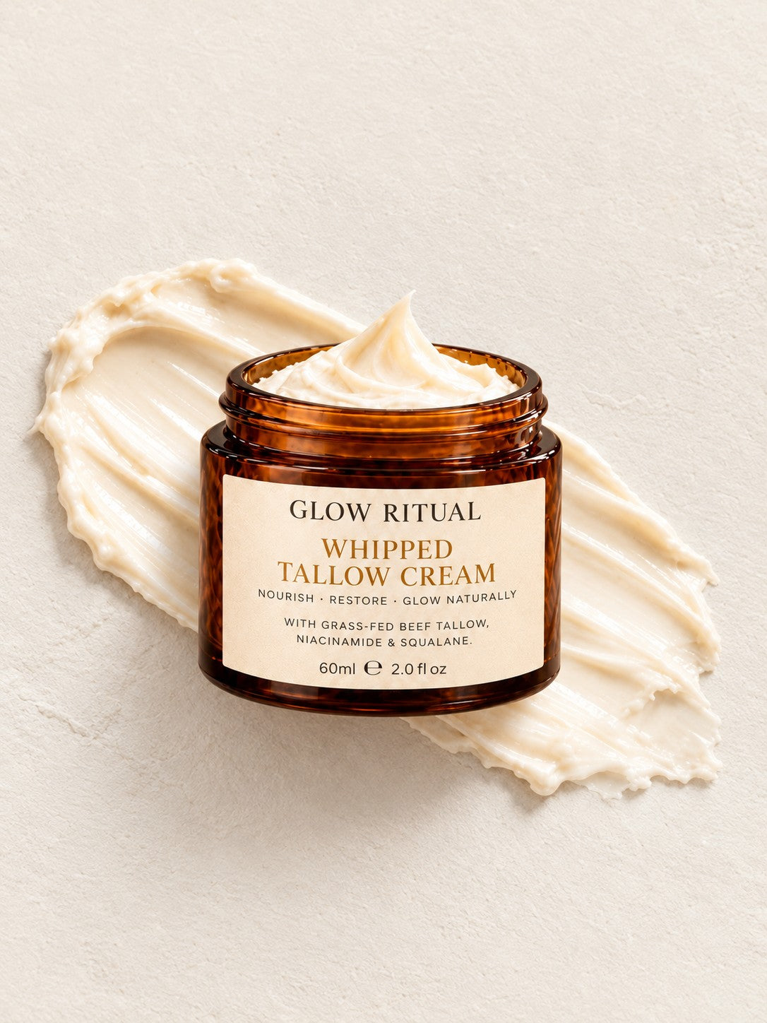 Glow Ritual Whipped Tallow Cream 60 ml jar on a cream swatch